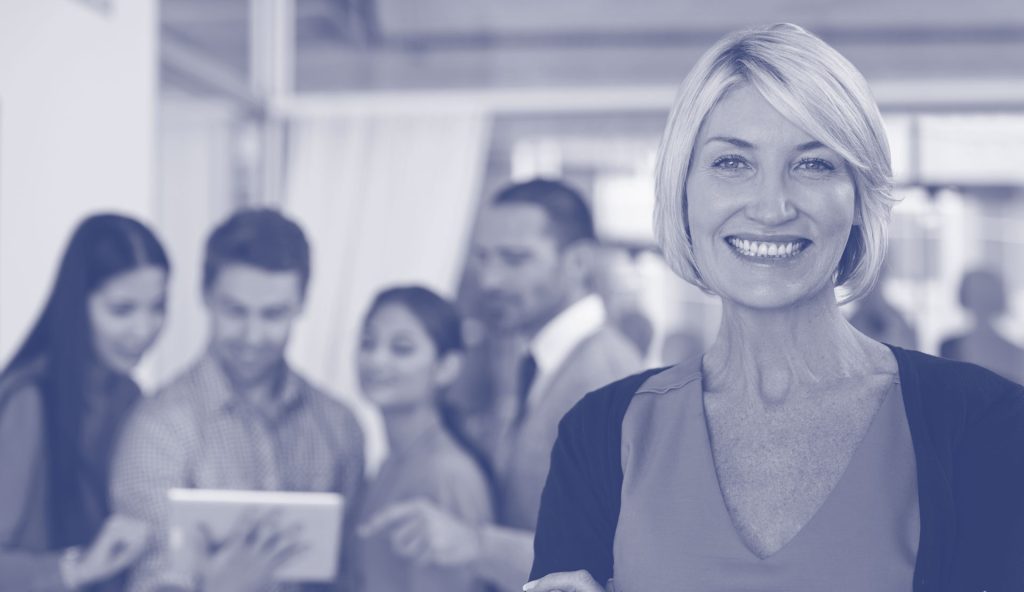 A grey/blue lens with a lady smiling with people behind her. Teammates. 